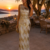 Maxi vestido de lentejuelas oro rosa tipo pareo. Cinturón lentejuelas ajustable en cintura. Parte superior gasa transparente con plumas. Incluye combinación. Composición: 95% Poliéster, 5% Elastano. Alabama Shop