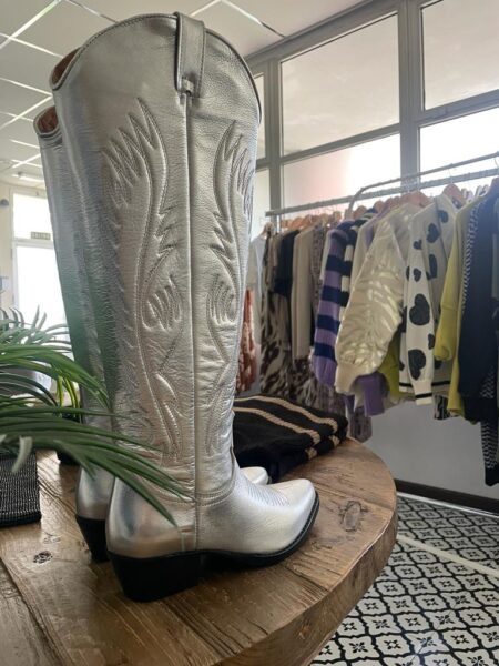 Botas estilo cowboy de caña alta en color plata. Corte en v en parte delantera y trasera. Altura caña: 46cm Altura tacón:5cm. Piel. Alabama Shop