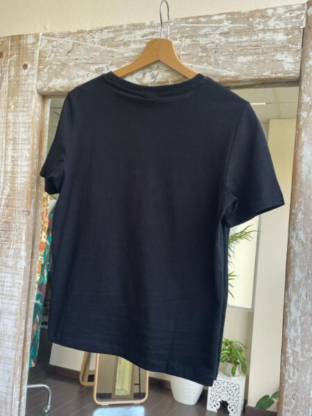 Camiseta sybil en color negro con detalle de dibujo en la parte frontal en terciopelo blanco. Cuello redondo y manga corta. Tallas de la xs a la l. Composición: 100% algodón. Alabama Shop