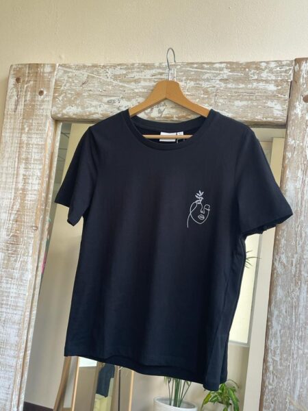 Camiseta sybil en color negro con detalle de dibujo en la parte frontal en terciopelo blanco. Cuello redondo y manga corta. Tallas de la xs a la l. Composición: 100% algodón. Alabama Shop