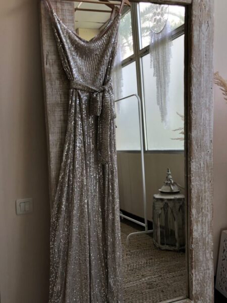 <p>Maxi vestido de lentejuelas. Incluye cinturón para poder ajustar en la cintura. Escote con caída. Composición: 95% Poliéster, 5% Elastano.</p> Alabama Shop