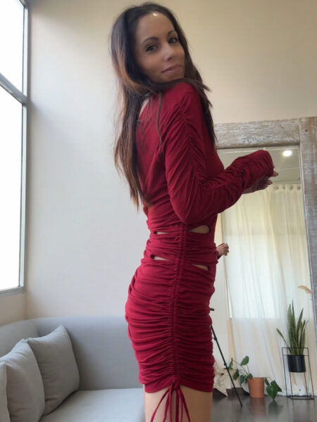 Vestido en color granate confeccionado en punto Vicenza. Elástico fruncido en las mangas y en un lado de la prenda. Abertura en la cintura. Cuello abierto con escote "un hombro". Tiras a un lado para regular el largo. Composición: 100% viscosa. Alabama Shop