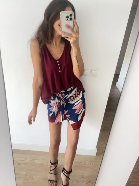 TOP FLUIDO BOTONES BURGUNDY 2 Top ciruela de tirantes. Tejido fluido. Escote pico. Tirantes anchos. Botones decorativos. Composición: 95% Viscosa, 5% Elastano Hecho en Italia Alabama Shop