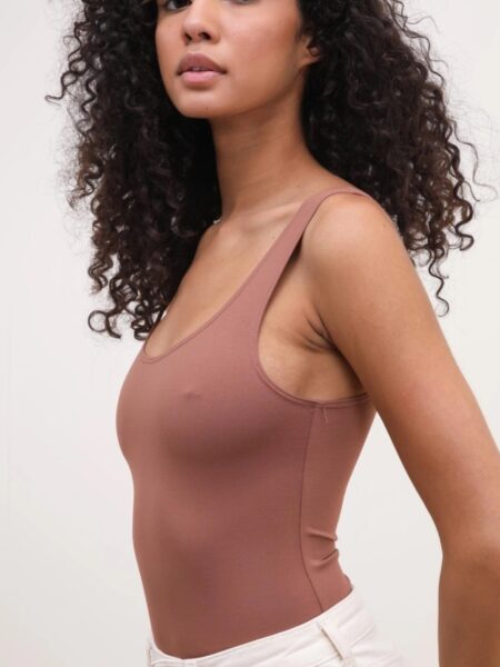 Body liso de suave algodón. Tirantes y escote redondeado. Cierre inferior con corchetes. Tallaje ajustado. Si estás entre dos tallas te recomendamos la más grande. 100% algodón. Alabama Shop