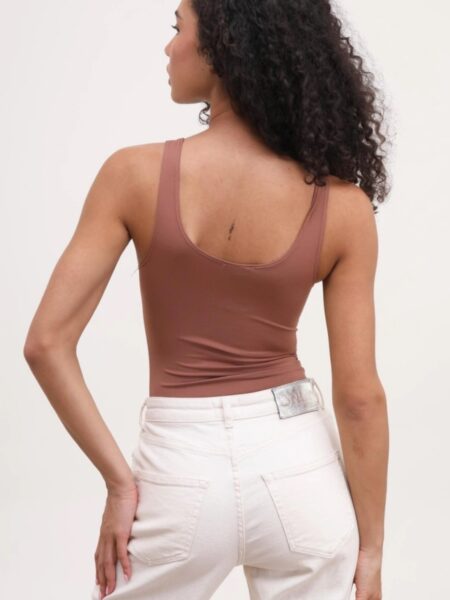 Body liso de suave algodón. Tirantes y escote redondeado. Cierre inferior con corchetes. Tallaje ajustado. Si estás entre dos tallas te recomendamos la más grande. 100% algodón. Alabama Shop