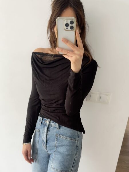 Top elástico con hombro asimétrico ligeramente más caído y detalle de encaje interior que asoma delicadamente por el escote y el bajo. Femenino, versátil y perfecto para elevar cualquier look. <strong>Composición:</strong> 90% algodón, 10% elastán. Alabama Shop