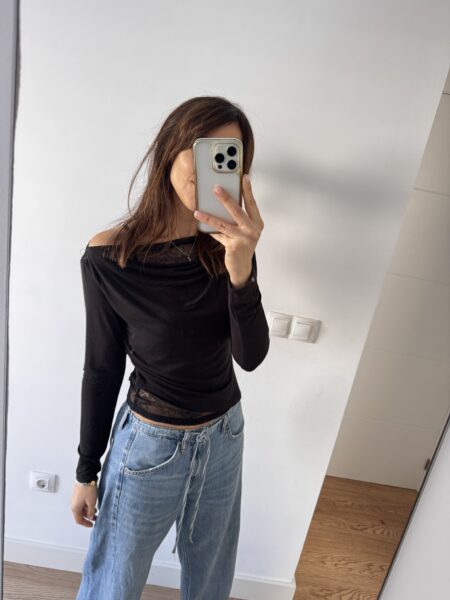 Top elástico con hombro asimétrico ligeramente más caído y detalle de encaje interior que asoma delicadamente por el escote y el bajo. Femenino, versátil y perfecto para elevar cualquier look. <strong>Composición:</strong> 90% algodón, 10% elastán. Alabama Shop