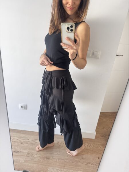 Pantalón con volantes que aporta movimiento y un aire muy femenino al look. Su diseño especial crea una silueta fluida y estilosa que transforma cualquier outfit en algo diferente. Perfecto para combinar con tops sencillos y dejar que el pantalón sea el protagonista. Poliéster (95%), Elastano (5%) Alabama Shop