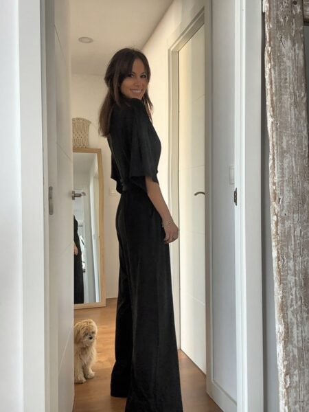 El mono negro que siempre apetece tener en el armario. Elegante, cómodo y con un diseño favorecedor que estiliza la silueta gracias a su cintura marcada y su pantalón amplio de caída fluida. Su escote en pico y las mangas amplias crean un look femenino y sofisticado que funciona igual de bien para una cena especial, un evento o incluso con un estilo más relajado. Además, tiene bolsillos laterales que lo hacen todavía más práctico. Un mono versátil que puedes llevar con sandalias, tacones o incluso con una chaqueta vaquera para un look más casual. 65% Polyester 30% Viscose 5% Elasthanne Alabama Shop