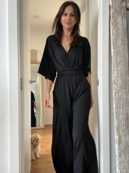 El mono negro que siempre apetece tener en el armario. Elegante, cómodo y con un diseño favorecedor que estiliza la silueta gracias a su cintura marcada y su pantalón amplio de caída fluida. Su escote en pico y las mangas amplias crean un look femenino y sofisticado que funciona igual de bien para una cena especial, un evento o incluso con un estilo más relajado. Además, tiene bolsillos laterales que lo hacen todavía más práctico. Un mono versátil que puedes llevar con sandalias, tacones o incluso con una chaqueta vaquera para un look más casual. 65% Polyester 30% Viscose 5% Elasthanne Alabama Shop