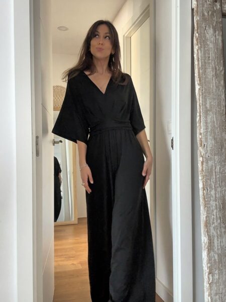 El mono negro que siempre apetece tener en el armario. Elegante, cómodo y con un diseño favorecedor que estiliza la silueta gracias a su cintura marcada y su pantalón amplio de caída fluida. Su escote en pico y las mangas amplias crean un look femenino y sofisticado que funciona igual de bien para una cena especial, un evento o incluso con un estilo más relajado. Además, tiene bolsillos laterales que lo hacen todavía más práctico. Un mono versátil que puedes llevar con sandalias, tacones o incluso con una chaqueta vaquera para un look más casual. 65% Polyester 30% Viscose 5% Elasthanne Alabama Shop