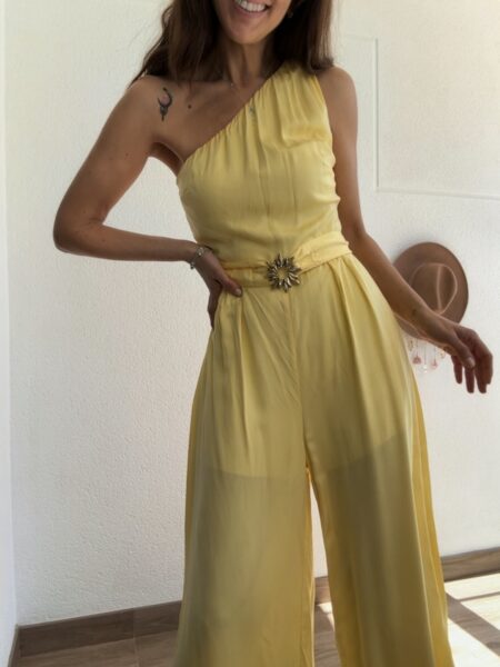 Mono largo de <strong>Lez a Lez</strong> en un precioso <strong>amarillo claro, luminoso, solar</strong>. Su diseño de <strong>un solo hombro</strong> aporta un aire sofisticado y femenino, mientras que el tejido de viscosa con ligero brillo cae con elegancia sobre la silueta. Incluye cinturón con hebilla en forma de sol que marca la cintura y un delicado recorte con lazo en la espalda que añade un detalle especial. Un <strong>mono elegante perfecto para bodas, bautizos, comuniones y eventos de primavera y verano</strong>, ideal si buscas un look alegre, sofisticado y diferente. <strong>Composición:</strong> 100% viscosa. Alabama Shop