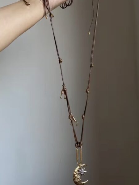 <b data-path-to-node="5" data-index-in-node="0">Collar Boho Luna y Estrella - Diseño Artesanal Multicapa</b> Añade un toque celestial a tu estilo con este collar de cordones múltiples y colgante de luna martillada. Un diseño de aire místico y bohemio con detalles en oro envejecido y estrella brillante, ideal para combinar con texturas naturales y looks relajados. Alabama Shop