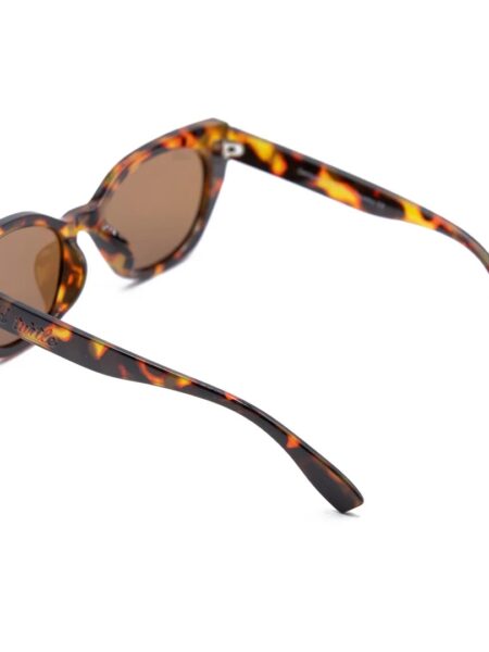 GAFAS DE SOL FLY ROSEE 3 <strong>Esencia retro, carácter moderno y protección total.</strong> El modelo <strong>Fly Rosee</strong> destaca por su carismática silueta geométrica de estilo cat-eye y un atemporal estampado carey en tonos marrones y miel. Equipadas con <strong>lentes polarizadas, protección UV400 y categoría 3</strong>, estas gafas combinan unos cristales marrones de alta nitidez con sutiles detalles dorados en el frontal. El accesorio perfecto para aportar fuerza, personalidad y un aire vintage irresistible a cualquier look diario mientras cuidas al máximo tu mirada. Alabama Shop