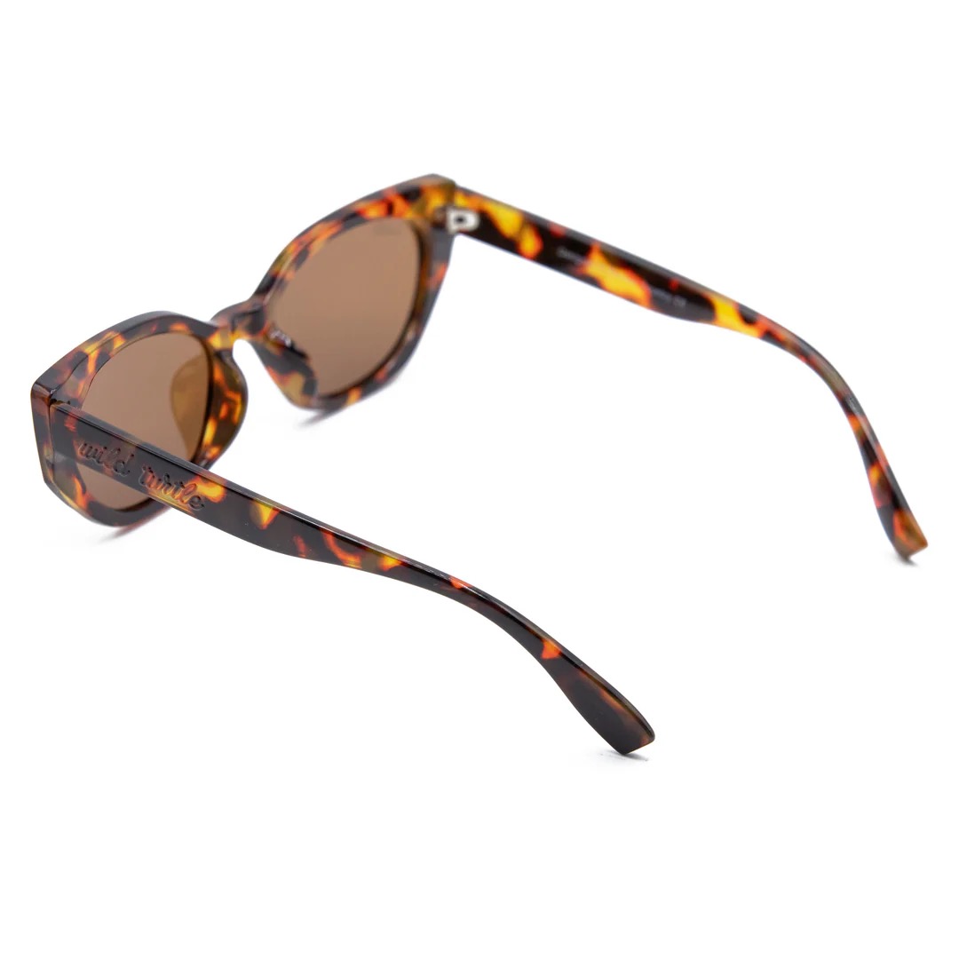 imagen-204 <strong>Esencia retro, carácter moderno y protección total.</strong> El modelo <strong>Fly Rosee</strong> destaca por su carismática silueta geométrica de estilo cat-eye y un atemporal estampado carey en tonos marrones y miel. Equipadas con <strong>lentes polarizadas, protección UV400 y categoría 3</strong>, estas gafas combinan unos cristales marrones de alta nitidez con sutiles detalles dorados en el frontal. El accesorio perfecto para aportar fuerza, personalidad y un aire vintage irresistible a cualquier look diario mientras cuidas al máximo tu mirada. Alabama Shop