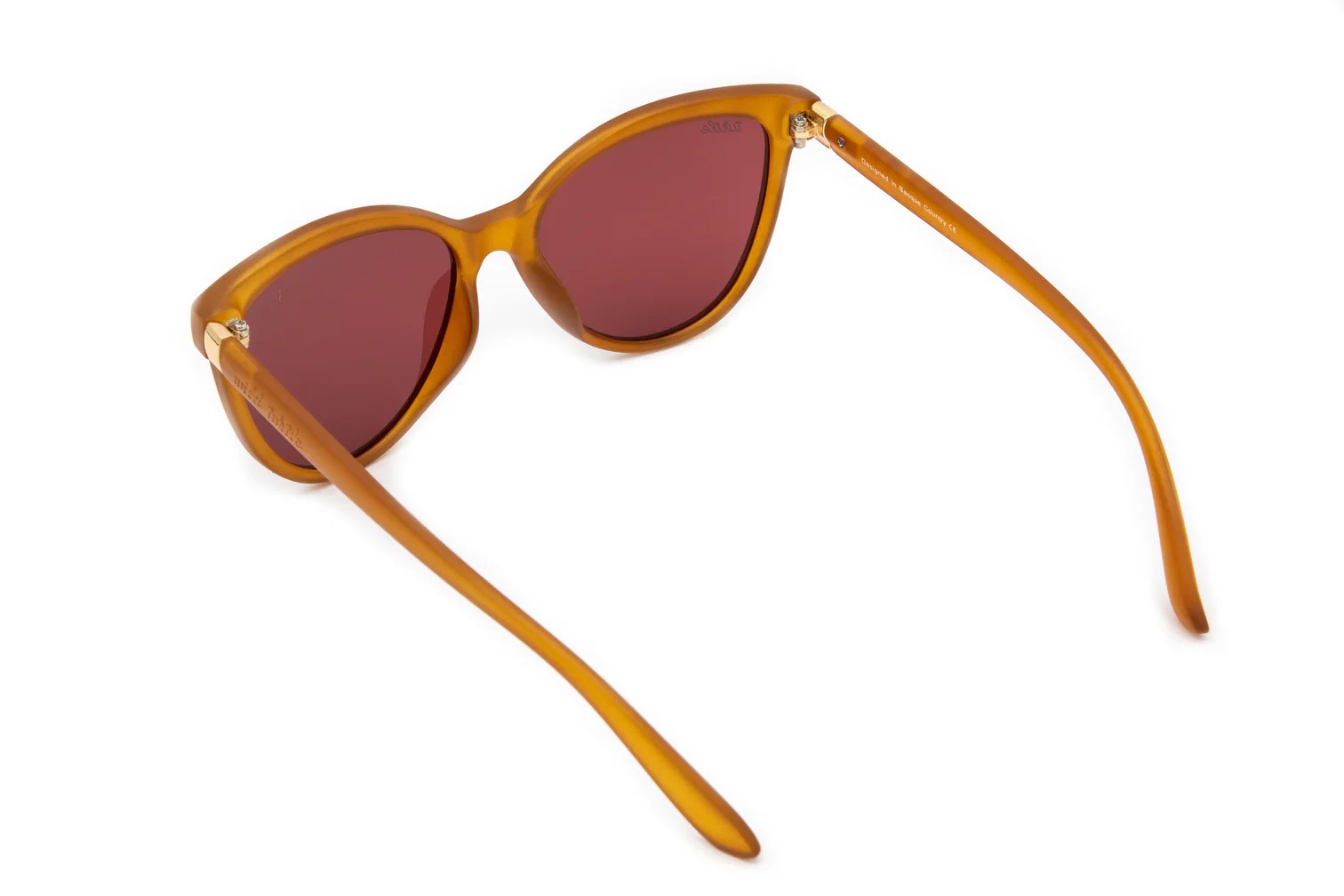 imagen-231 <strong>Personalidad, calidez y protección absoluta.</strong> Las gafas de sol Lady Kahlo destacan por su carismática silueta de inspiración cat-eye en un favorecedor tono ámbar traslúcido de acabado mate. Equipadas con <strong>lentes polarizadas, protección UV400 y categoría 3</strong>, este modelo combina unos cristales en tono marrón rojizo con un sutil detalle dorado en la patilla. El accesorio ideal para aportar luz al rostro y un toque boho-chic único a cualquier look, cuidando al máximo tu salud visual. Alabama Shop
