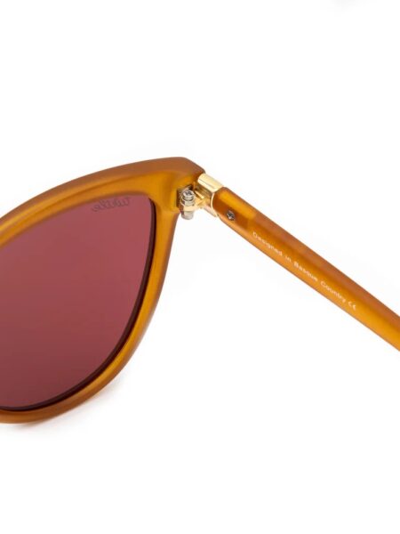 GAFAS DE SOL LADY KAHLO 7 <strong>Personalidad, calidez y protección absoluta.</strong> Las gafas de sol Lady Kahlo destacan por su carismática silueta de inspiración cat-eye en un favorecedor tono ámbar traslúcido de acabado mate. Equipadas con <strong>lentes polarizadas, protección UV400 y categoría 3</strong>, este modelo combina unos cristales en tono marrón rojizo con un sutil detalle dorado en la patilla. El accesorio ideal para aportar luz al rostro y un toque boho-chic único a cualquier look, cuidando al máximo tu salud visual. Alabama Shop