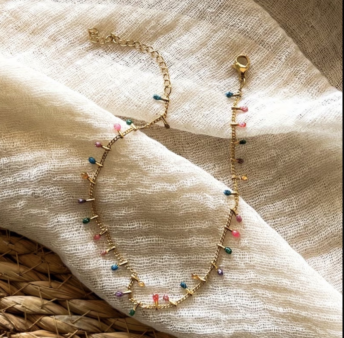 screenshot-277 La tobillera más divertida y colorida del verano ✨ Una cadena dorada de acero con pequeños charms multicolor que aporta un toque alegre, original y muy especial a cualquier look. Perfecta para llevar con sandalias, descalza en la playa o combinada con otras tobilleras para un estilo más boho. Tobillera dorada con detalles multicolor Largo ajustable: 20 cm + 5 cm Ancho aproximado: 6 mm Peso: 3 g Cierre de mosquetón Ligera, cómoda y fácil de combinar Alabama Shop